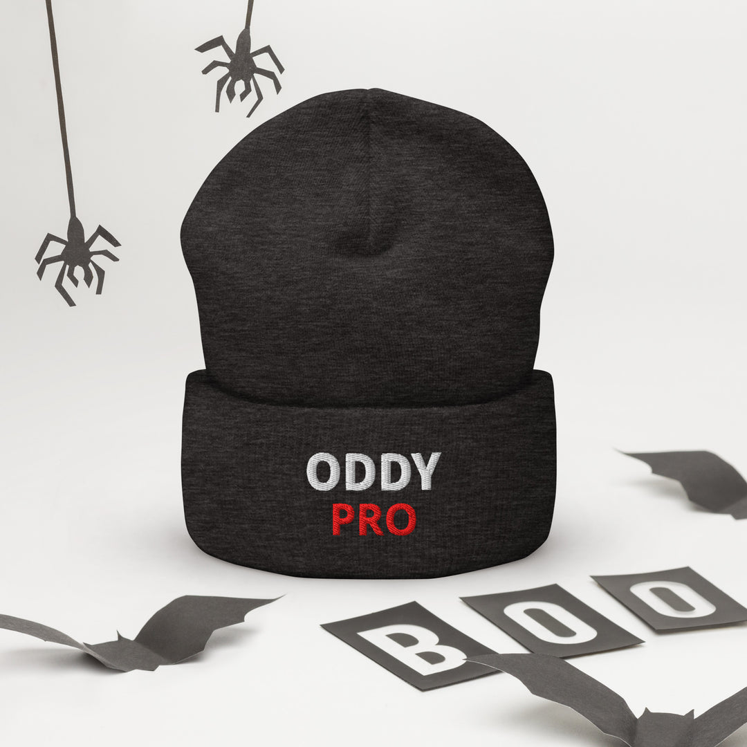 Oddy Pro Cuffed Beanie on a flat surface with Halloween decorations in the background, showcasing its snug design.