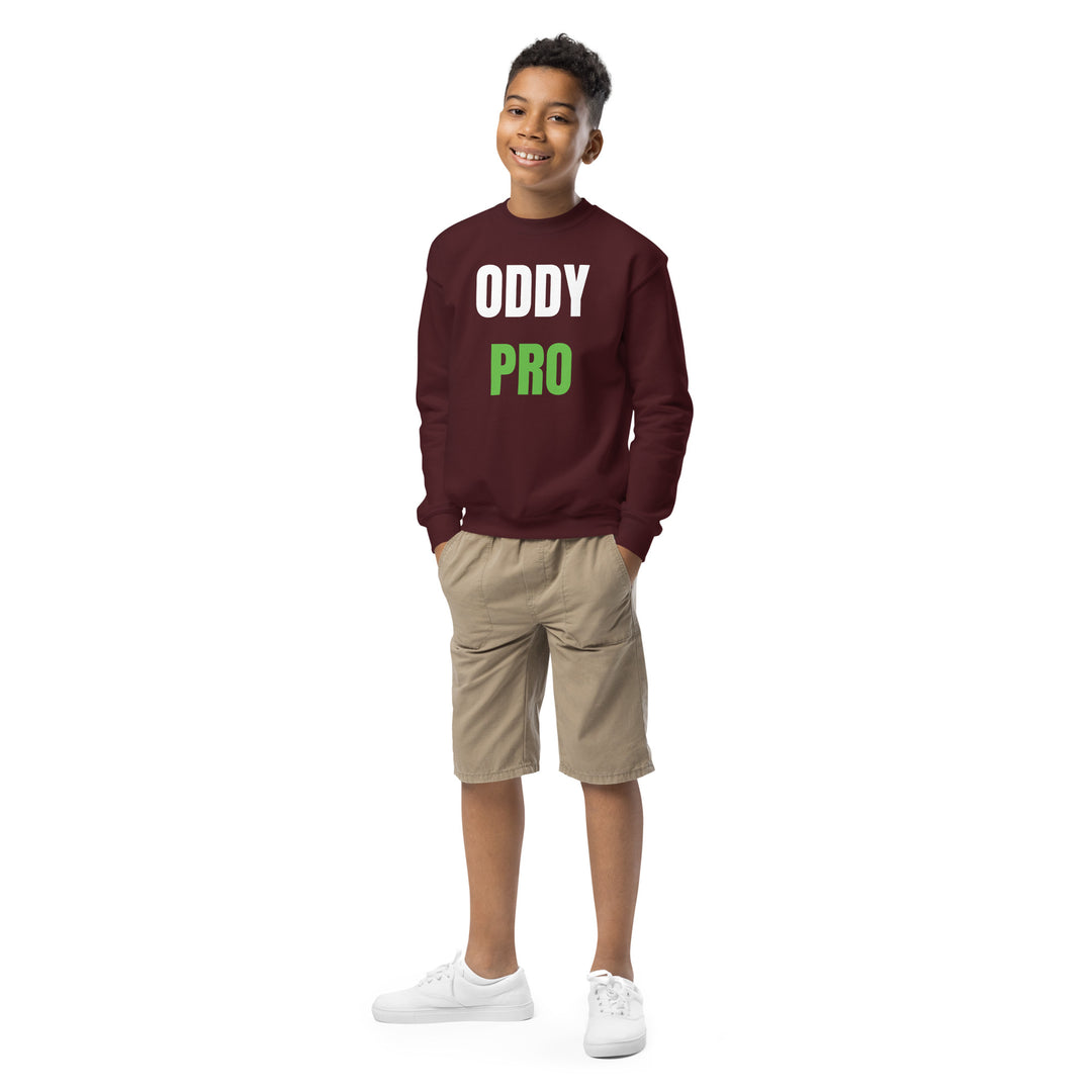 Oddy Pro Youth crewneck sweatshirt in burgundy, worn by a smiling boy in shorts, perfect for casual adventures.